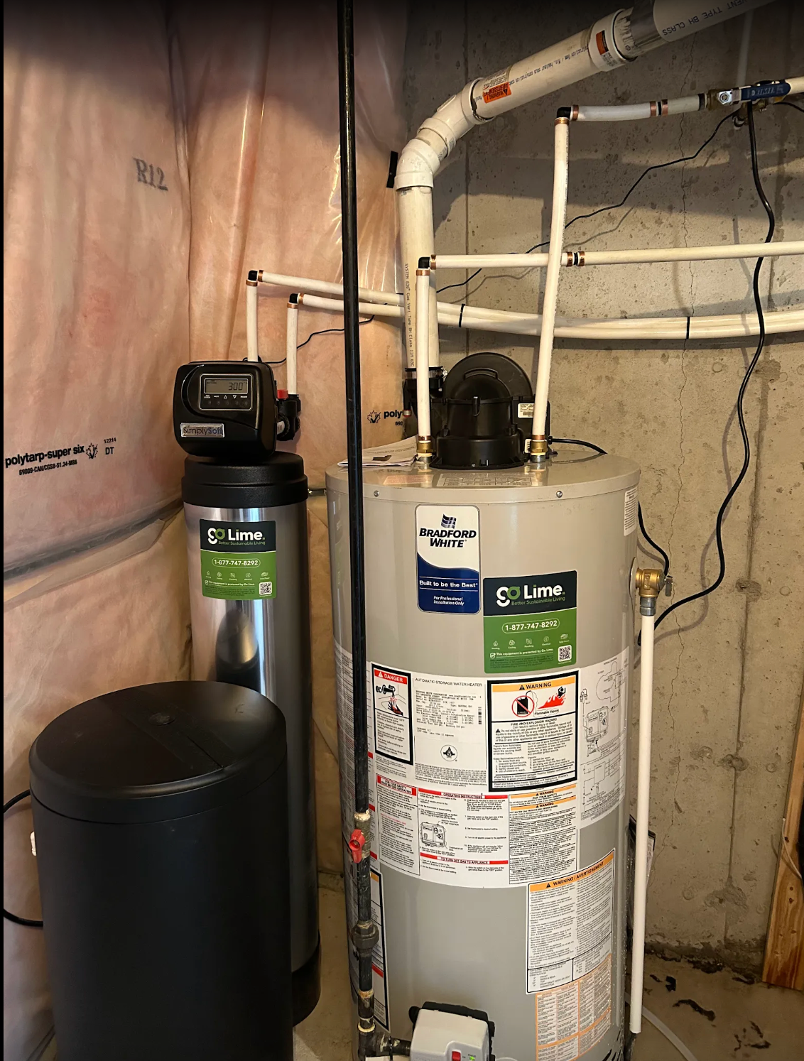 Water heater with pipes and a control panel in a basement setting