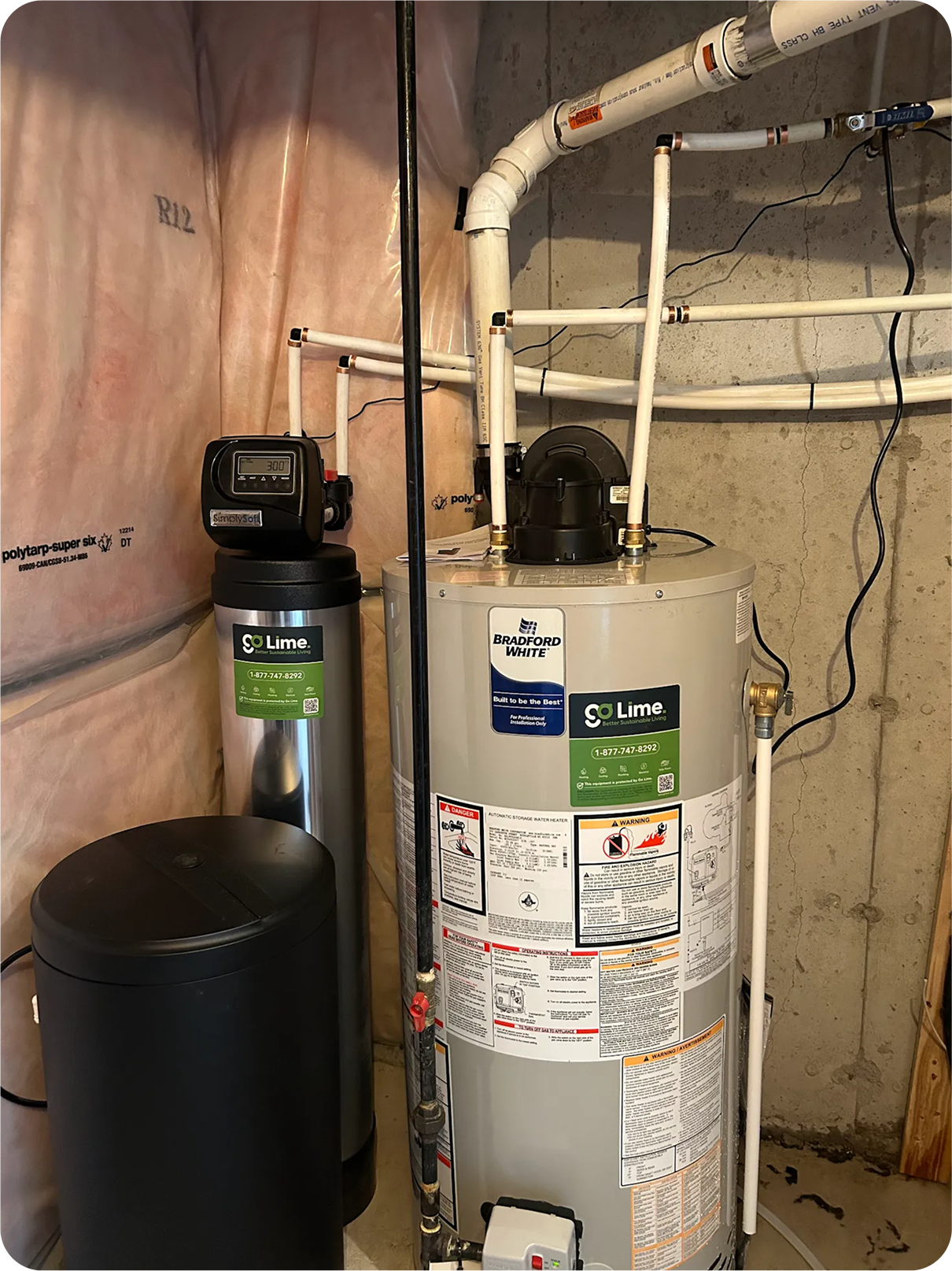 Water heater with pipes and a black cylindrical object